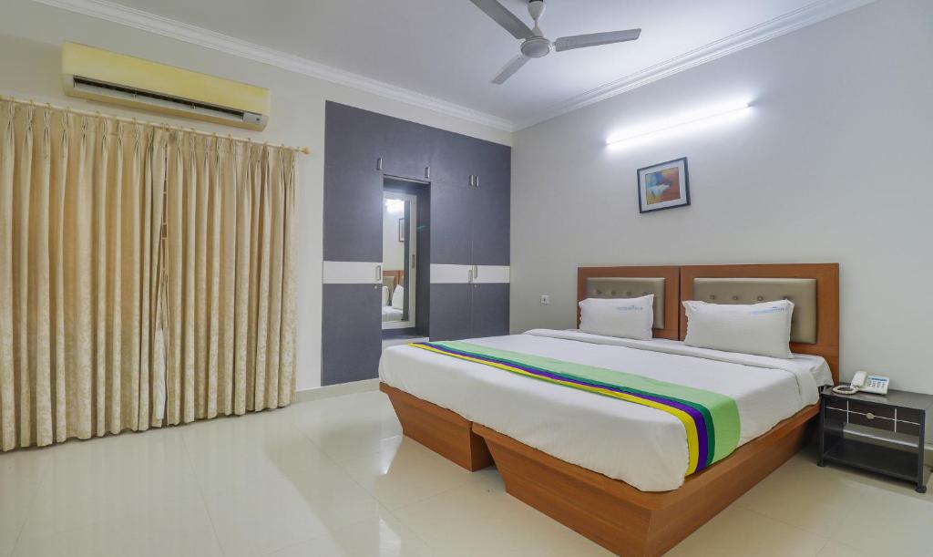 a bedroom with a large bed in a room at Treebo Trend Rithikha Inn Elite Chennai Trade Centre in Chennai