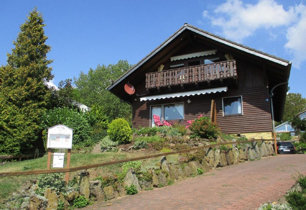 une maison en bois avec un balcon sur une colline dans l'établissement Ferienhaus Talblick, à Fladungen