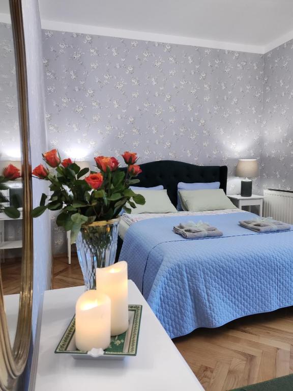 登比察的住宿－Villa Art deco，一间卧室,配有一张带花卉和蜡烛的床