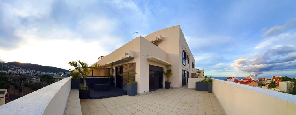 a white building on top of a balcony at L'Appartement en Haut in Saint-Denis