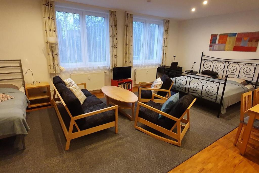 een woonkamer met stoelen en een tafel en een bed bij Campus Apartment Alexander in Dresden