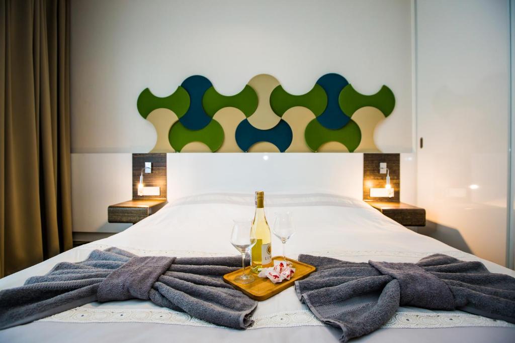 łóżko z ręcznikami, butelką i dwoma kieliszkami w obiekcie Aleja Baltic Park Molo 308 w Świnoujściu