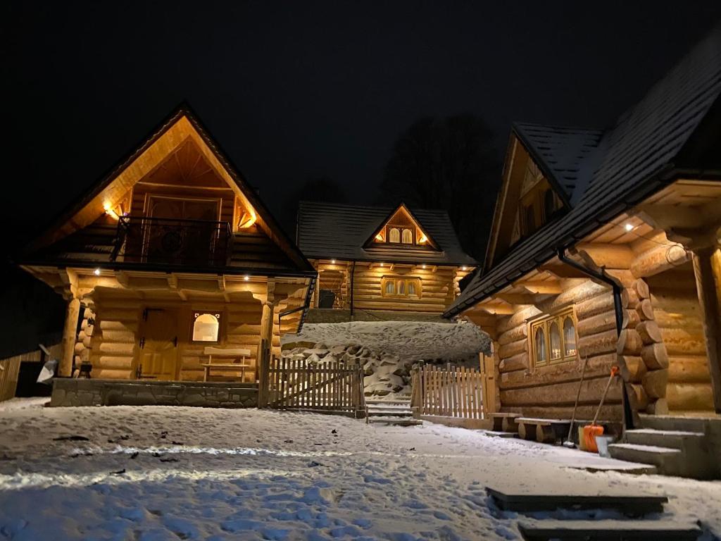 a log cabin in the snow at night at Tatra Break in Witów