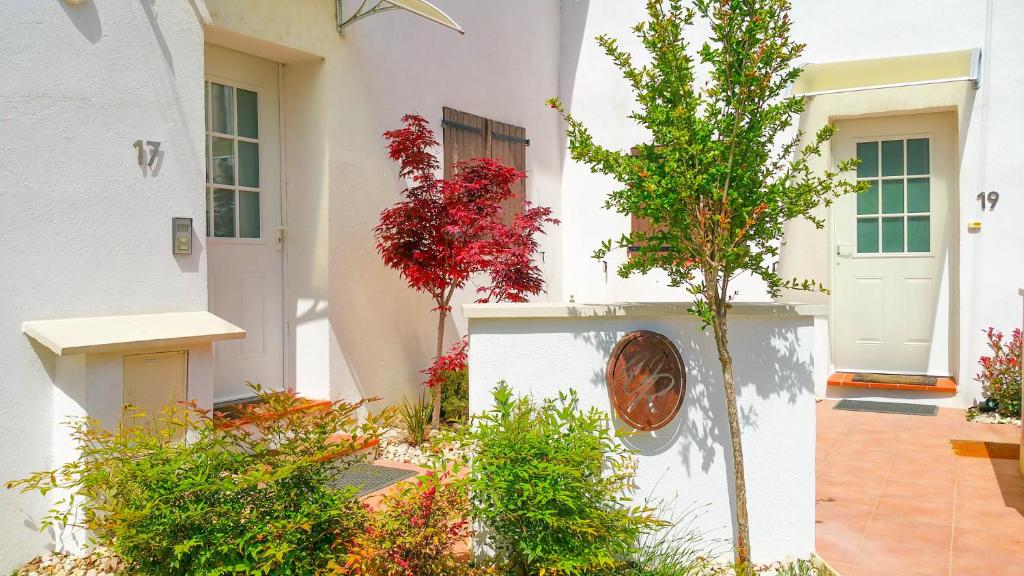 un bâtiment blanc avec une porte blanche et quelques plantes dans l'établissement VILLA REIALA Plan-de-Cuques, à Marseille