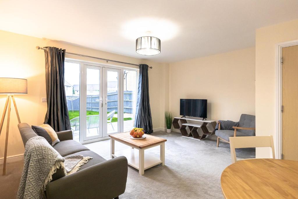 a living room with a couch and a table at Waterside Lodge by PAY AS U STAY in Milton Keynes