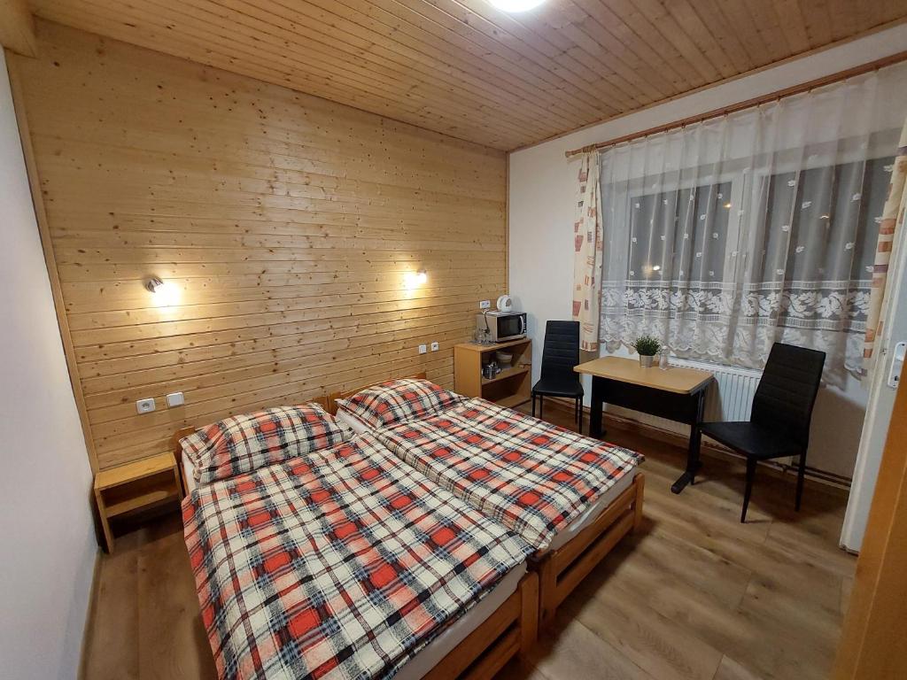 a bedroom with a bed and a table and chairs at Penzion Emílie in Jeseník