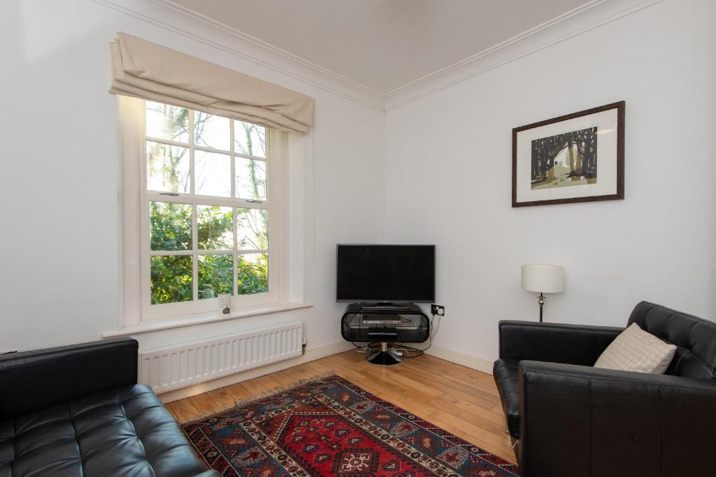uma sala de estar com um sofá e uma televisão em Apartment 4 The Grove em Durham