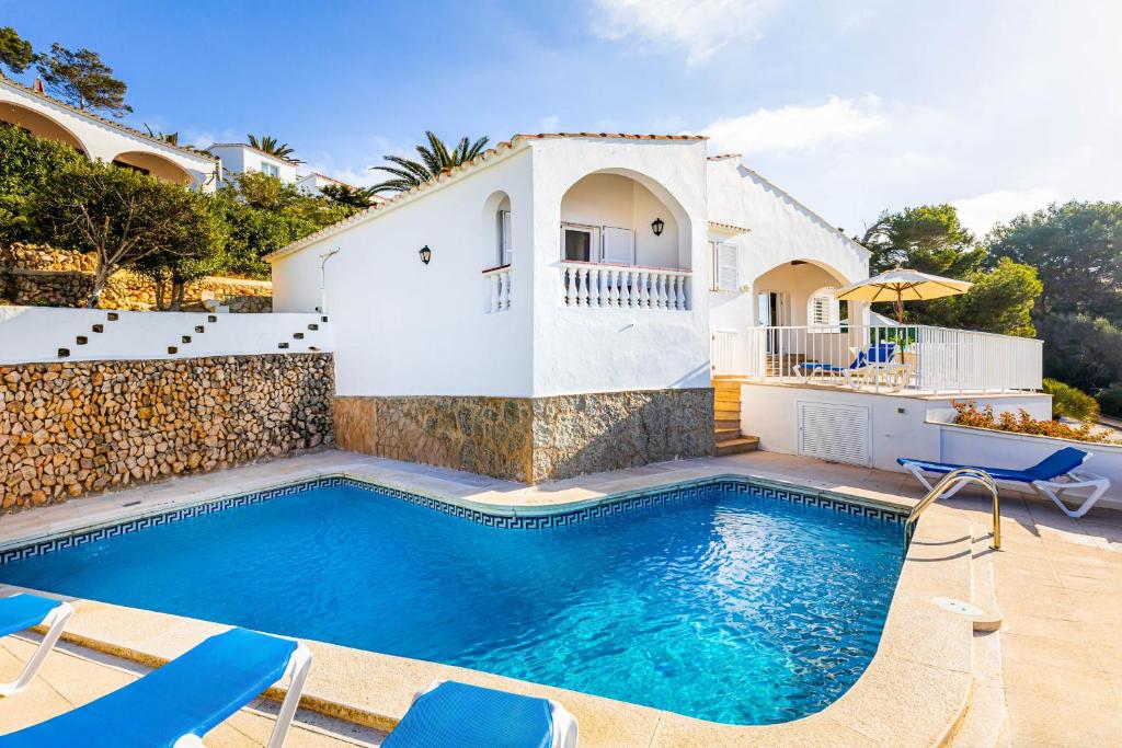 a villa with a swimming pool in front of a house at Villa Proa in Son Bou