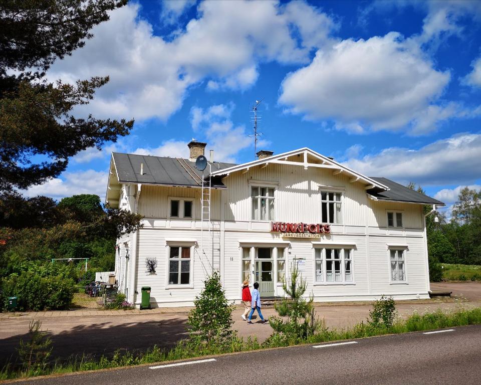 two people walking in front of a white house at Perrongen Guesthouse in Munkfors