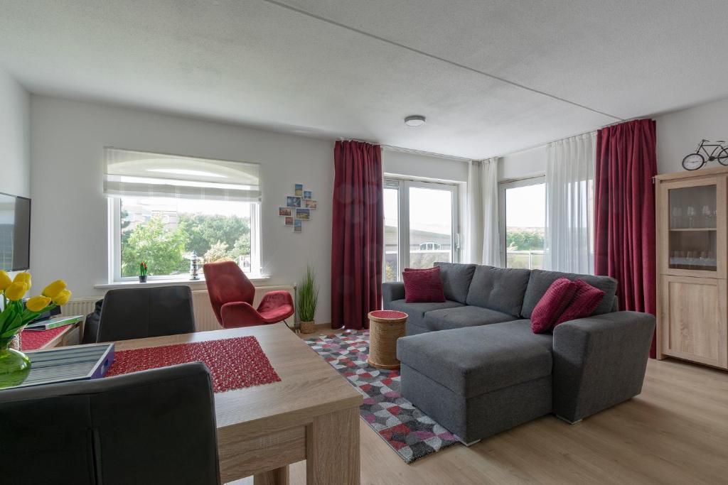 - un salon avec un canapé et une table dans l'établissement Residence Juliana appartement 53 -Julianadorp aan zee, à Julianadorp