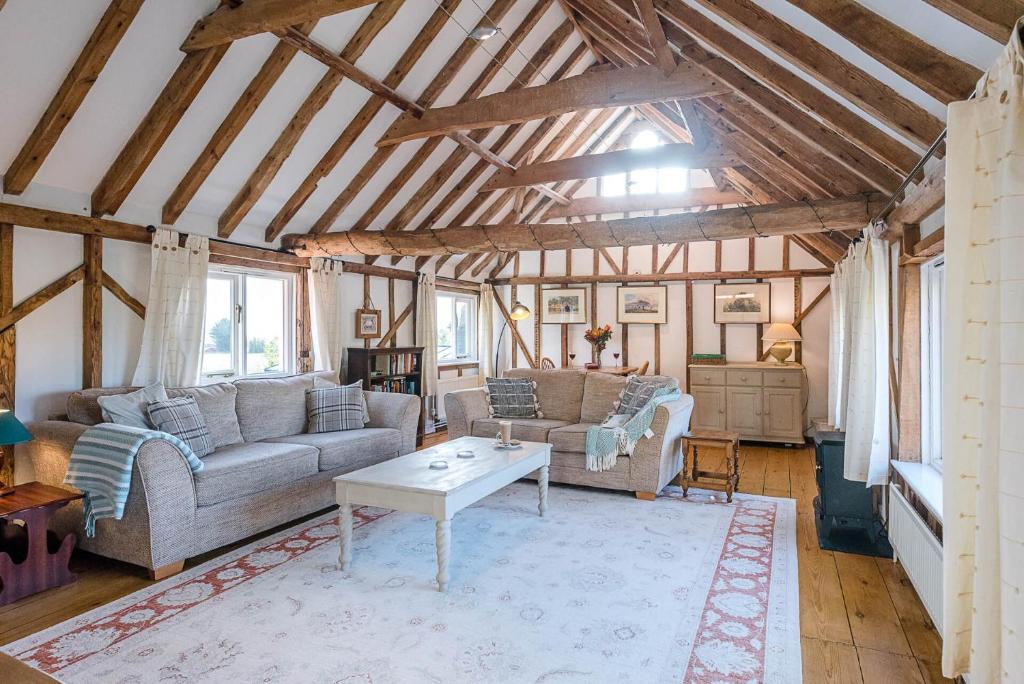 a living room with two couches and a table at The Hayloft Boundary Farm Air Manage Suffolk in Woodbridge