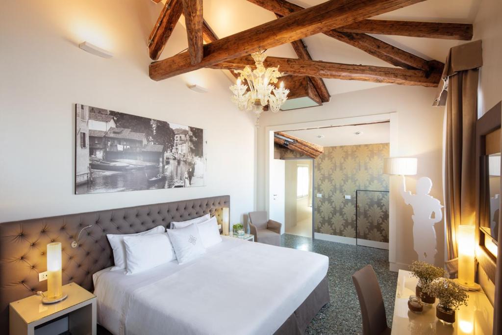 a bedroom with a large white bed and a table at Palazzo Barocci in Venice