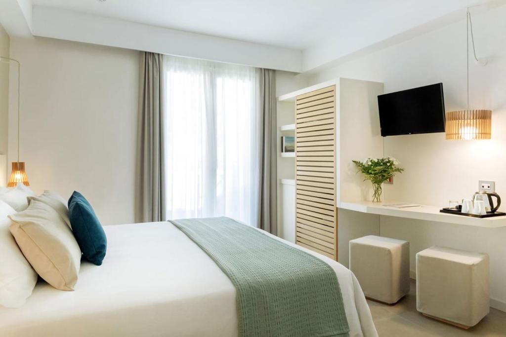 a bedroom with a large white bed and a television at Albatros Beach Hotel in Letojanni