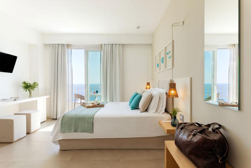a bedroom with a bed with a view of the ocean at Albatros Beach Hotel in Letojanni
