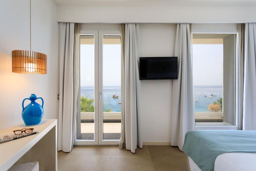a bedroom with a bed and a view of the ocean at Albatros Beach Hotel in Letojanni