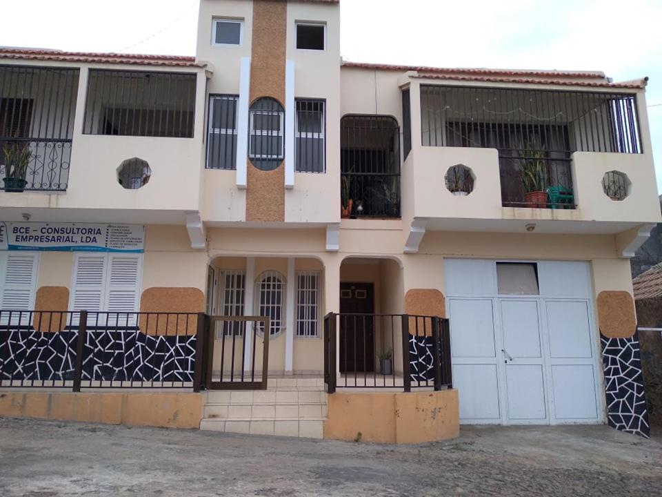 a white house with a lot of windows and gates at Pensão Domingas in São Filipe