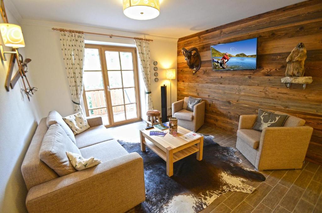 a living room with a couch and two chairs and a table at Appartementhaus Kristall at SchattbergXpress by All in One Apartments in Saalbach Hinterglemm