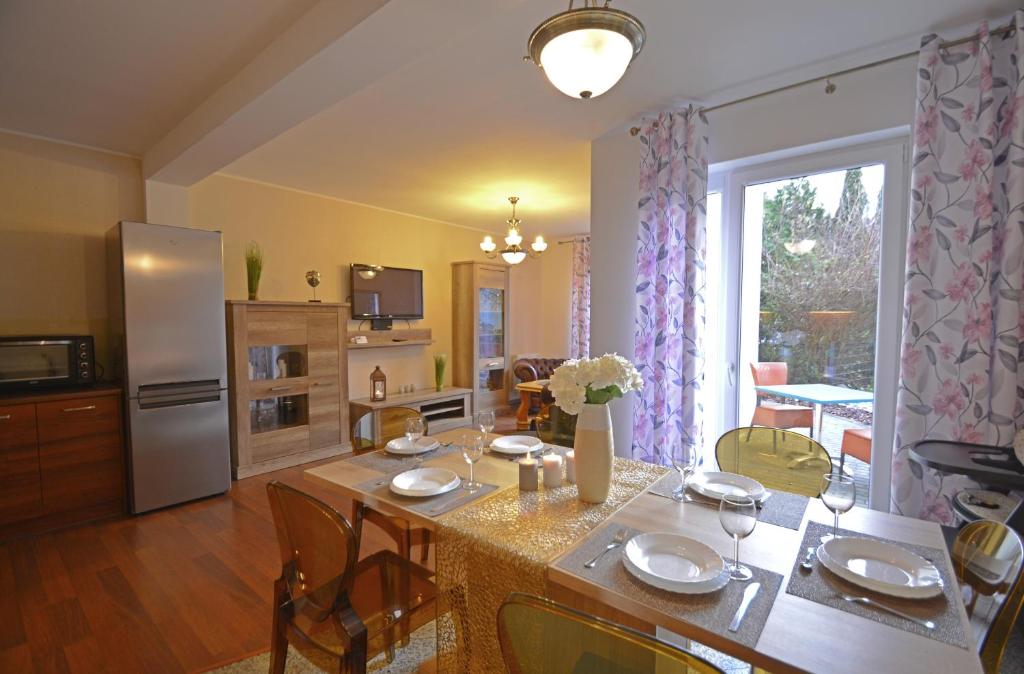kuchnia i salon ze stołem i krzesłami w obiekcie Apartamenty Bryza-Komandorska 3E- Family Home - Parking w Świnoujściu