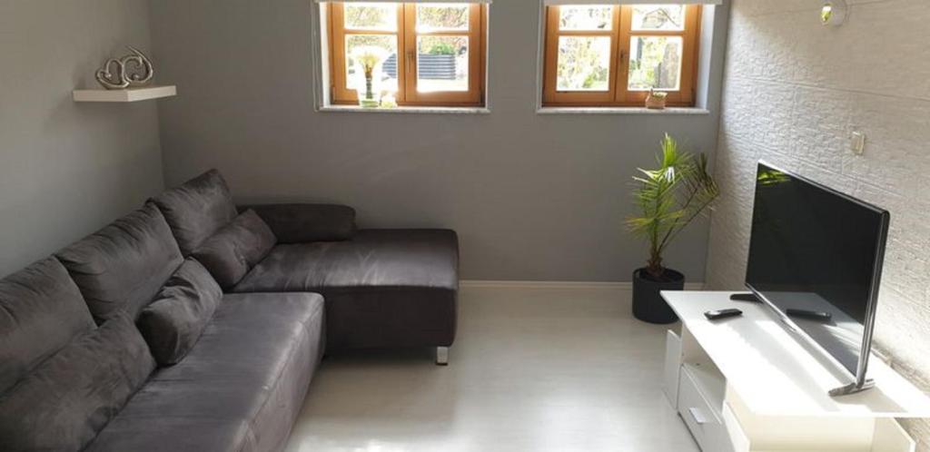 a living room with a couch and a tv at Ferienwohnung Gutwin in Bischofsheim an der Rhön