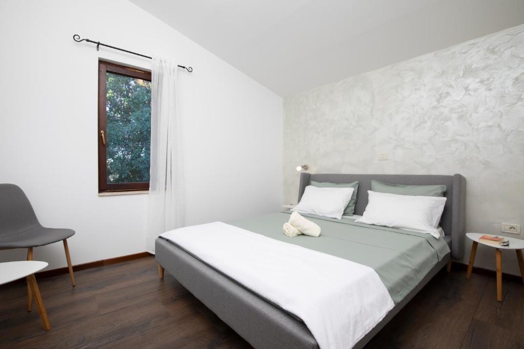 sypialnia z łóżkiem z białymi ścianami i oknem w obiekcie Sandy Bay Apartments - free mountainbike rental - w mieście Pješčana Uvala