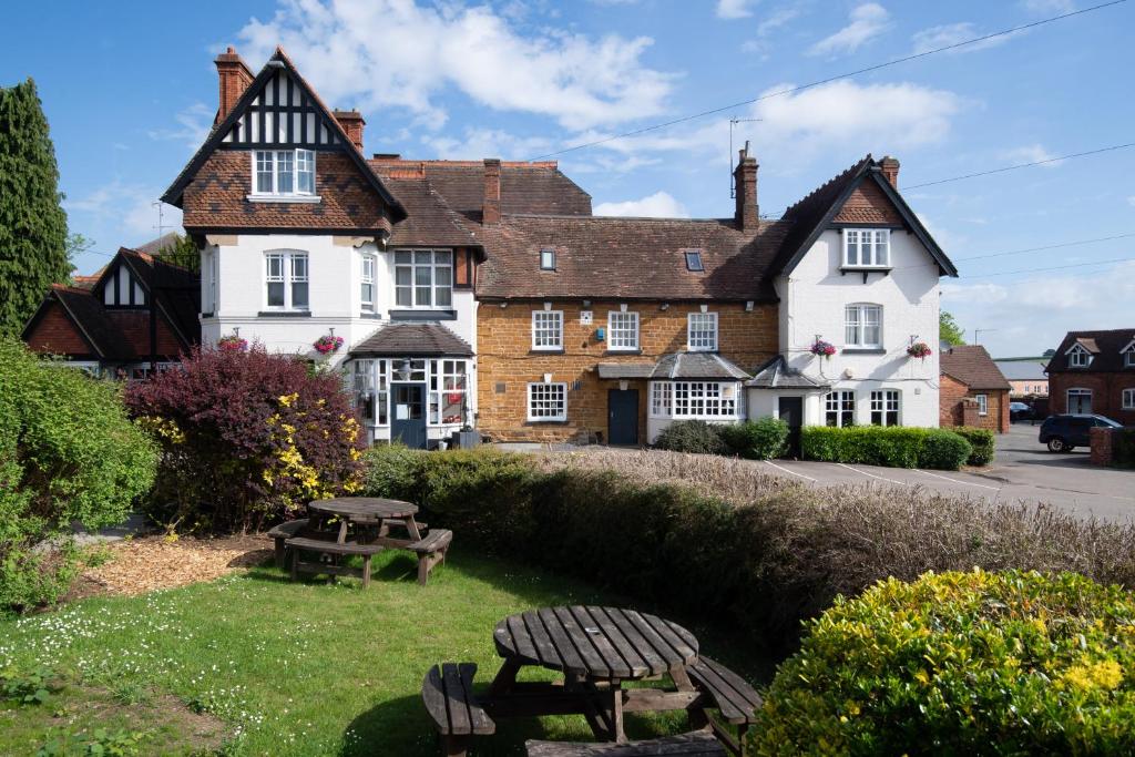 a large house with a picnic table in front of it at Heart of England, Northampton by Marston's Inns in Daventry