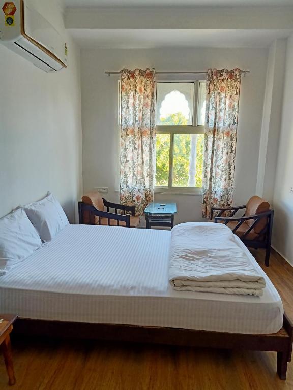 a bedroom with a large bed with a window at Hindupura Residency in Sawāi Mādhopur