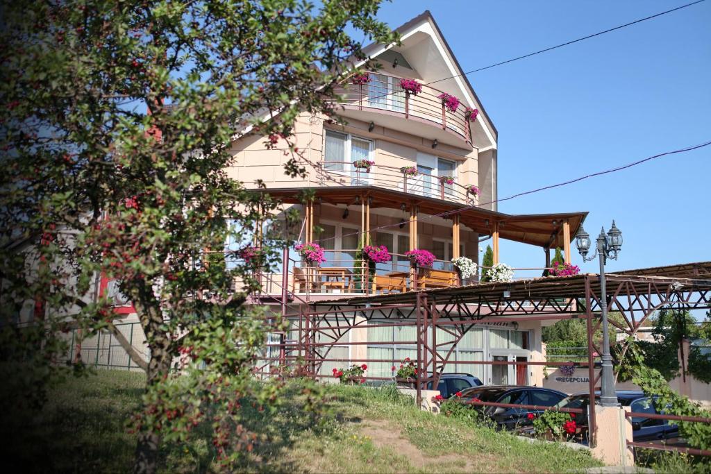 una casa con un balcón en el lateral. en Hotel Novella Uno en Novi Banovci