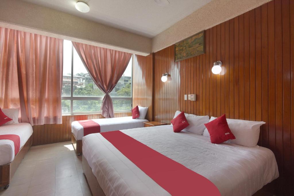 a hotel room with two beds and a window at OYO Hotel Totonacapan, Papantla in Papantla de Olarte