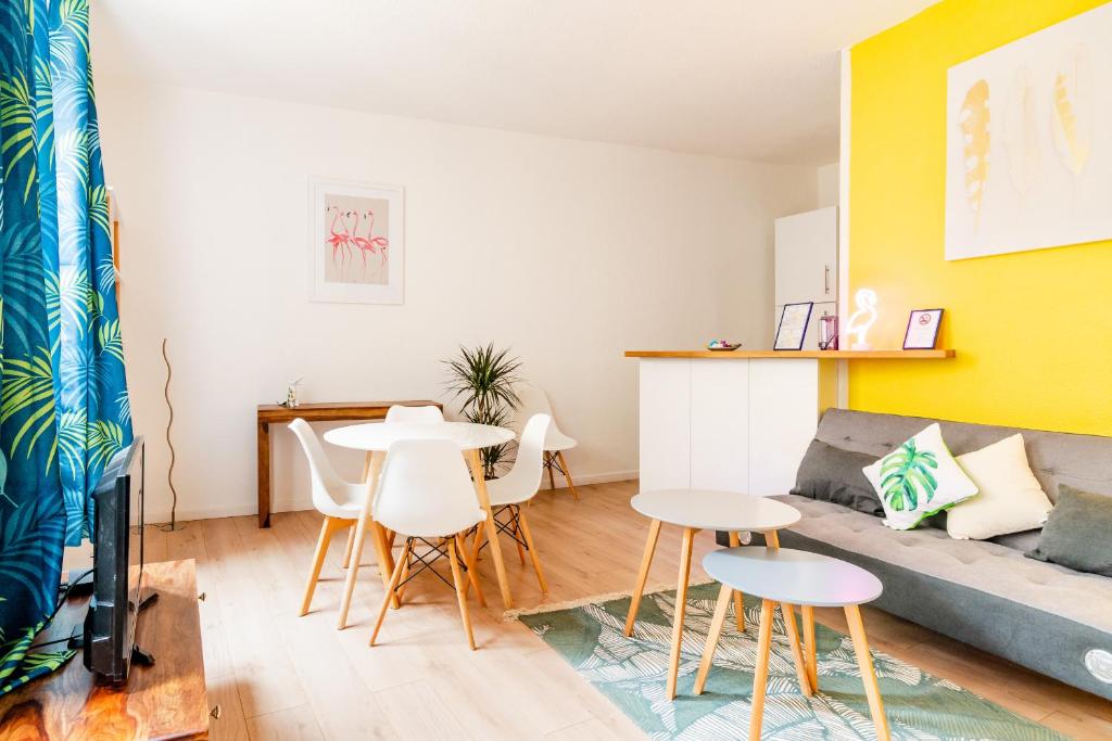 a living room with a couch and a table and chairs at DIFY Les Pentes - Centre-ville in Lyon