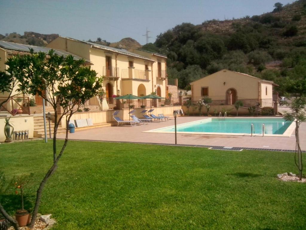 eine Villa mit einem Pool und einem Haus in der Unterkunft Patitiri in Santa Teresa di Riva