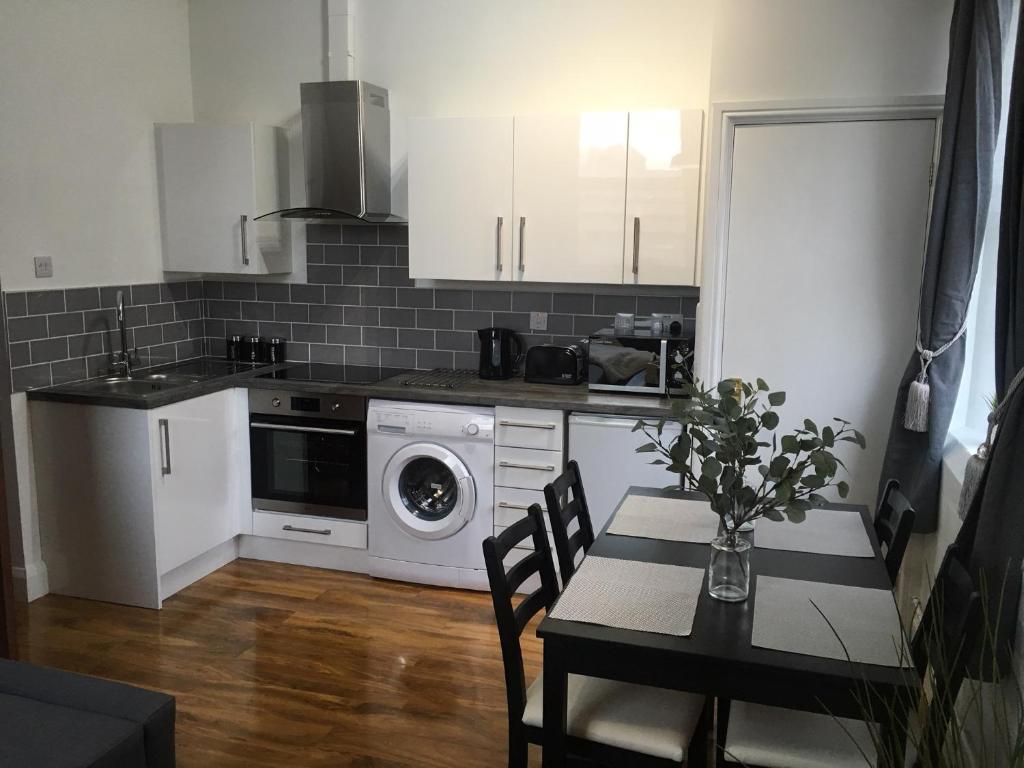 a kitchen with a table and a washing machine at The Holt in Leicester