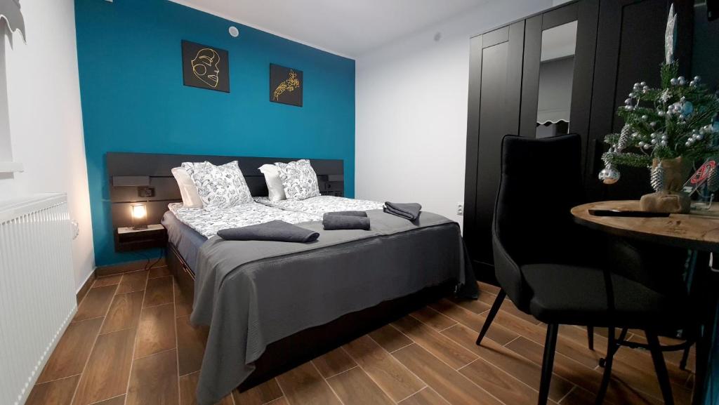 a bedroom with a bed with a blue wall at Magnolia Central Apartment in Sighişoara