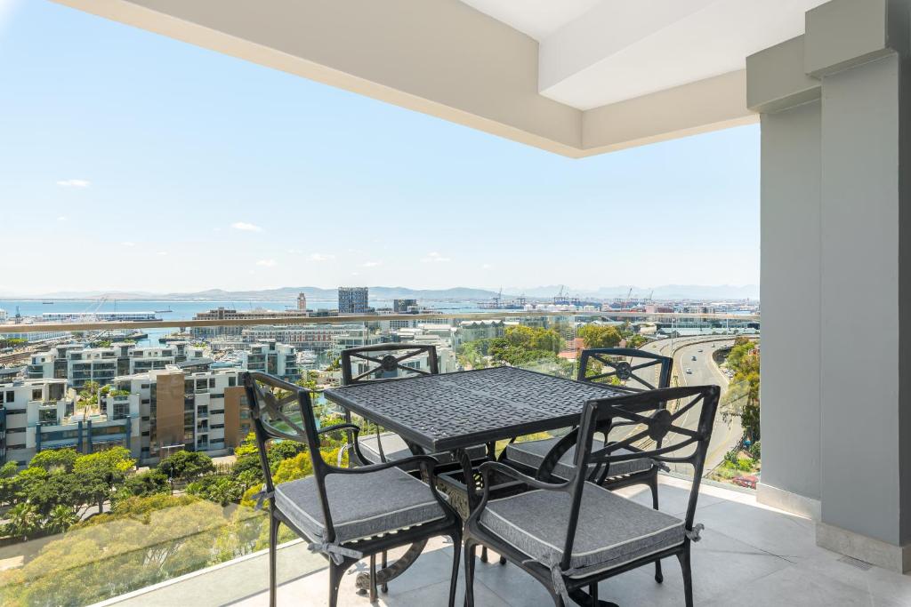 a table and chairs on a balcony with a view at Point Break Luxury Apartments in Cape Town