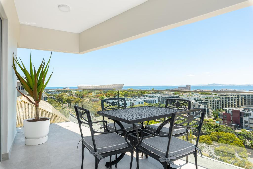 a table and chairs on a balcony with a view at Point Break Luxury Apartments in Cape Town