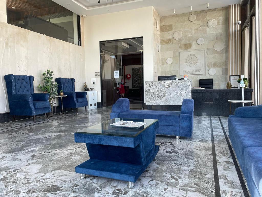 eine Lobby mit blauen Stühlen und einem Tisch in der Unterkunft Clover Inn in Udaipur