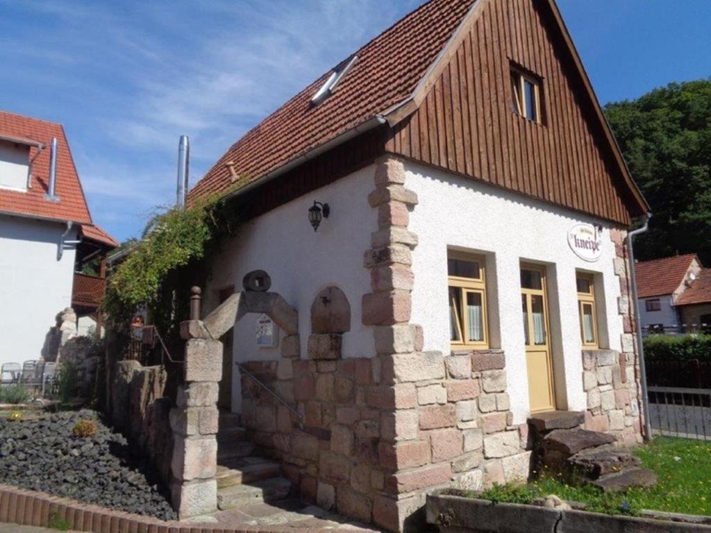 una pequeña casa de piedra con techo marrón en Ferienhaus Zur kleinen Kneipe en Fladungen