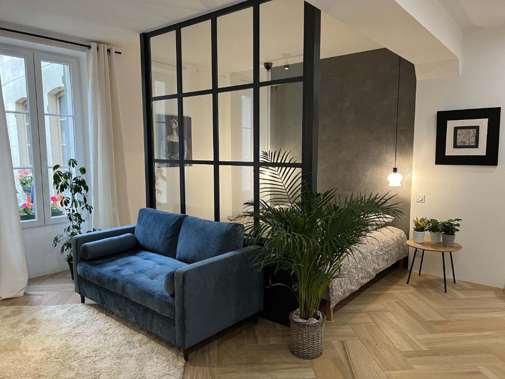 a living room with a blue couch and a bed at Bel appartement au centre du vieux Joigny in Joigny
