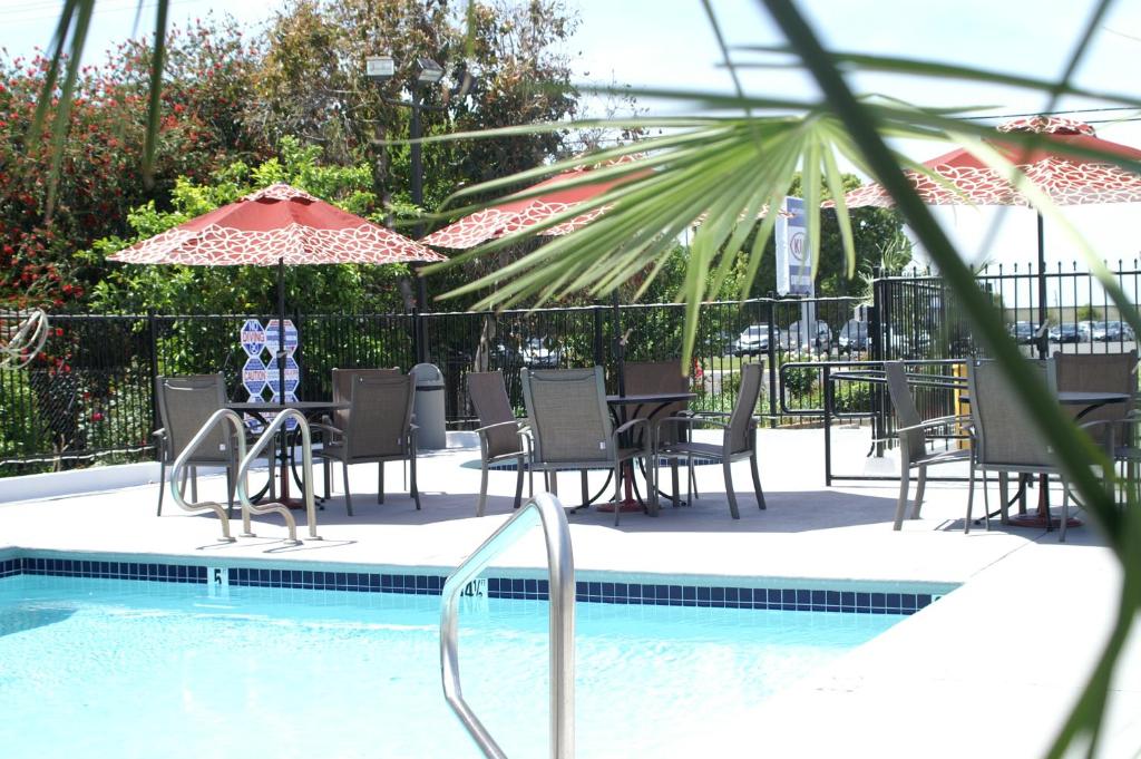 a pool with chairs and tables and an umbrella at Regency Inn in Vallejo
