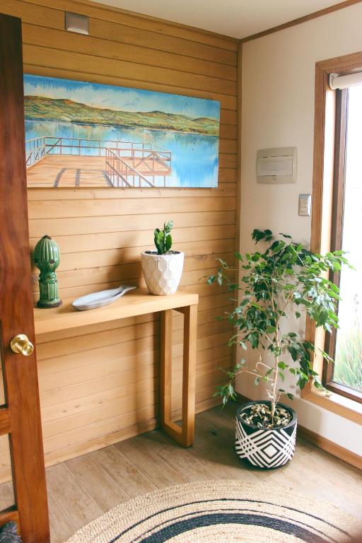 a room with a table and a painting of a boat at Cabañas Arrayanes de Huillinco en Chiloé in Chonchi