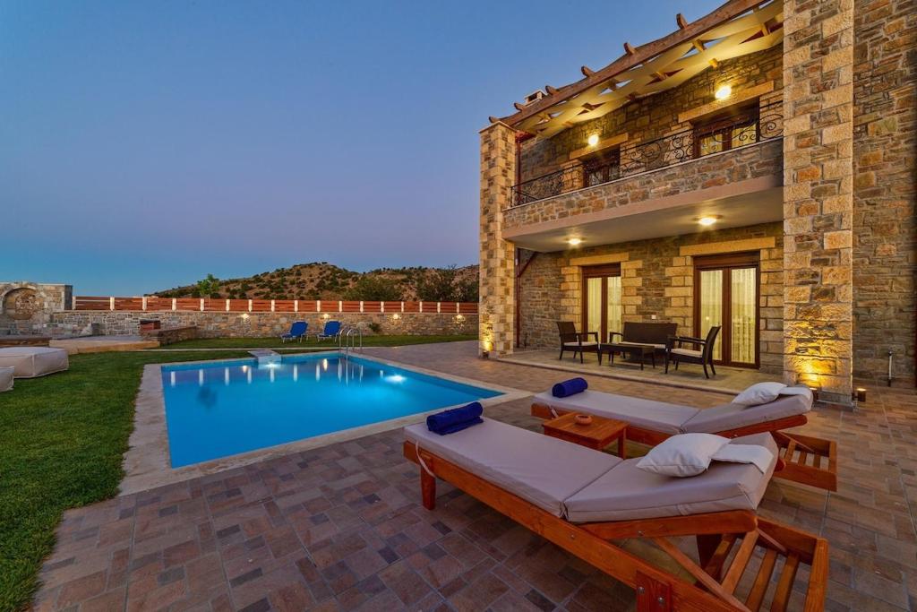 a villa with a swimming pool and a house at Asfendamos Villas in Zonianá