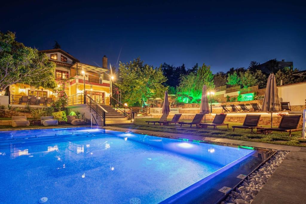 una piscina frente a una casa por la noche en Villa Staras - With Private Heated Pool & Jacuzzi en Gerani