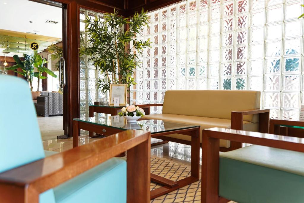 a restaurant with tables and chairs and windows at Hotel Khella in Hammamet