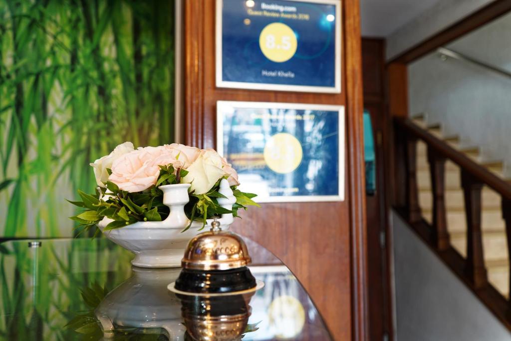 a vase with pink flowers sitting on a glass table at Hotel Khella in Hammamet