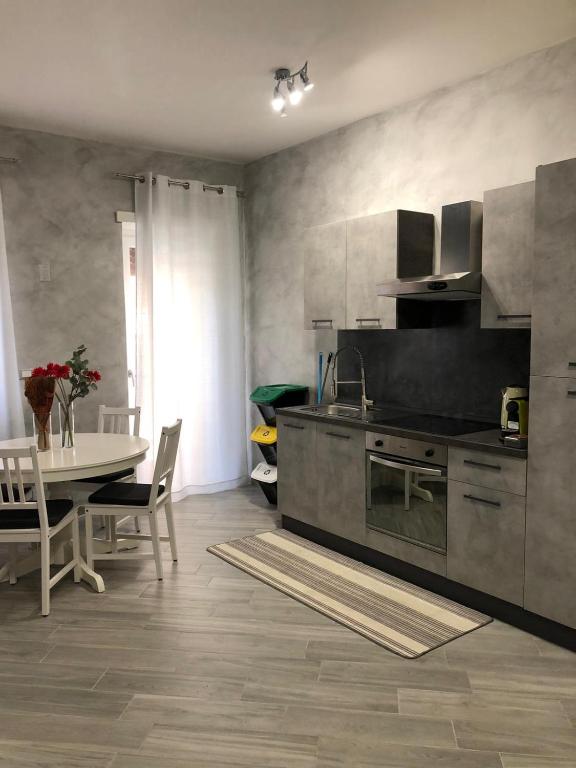 una cucina con tavolo, piano cottura e armadietti di LA LOGGIA a Roma