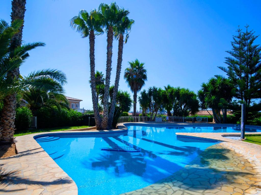 einen großen Pool mit Palmen im Hof in der Unterkunft Holiday Home Residencial Bel-Air by Interhome in Calpe