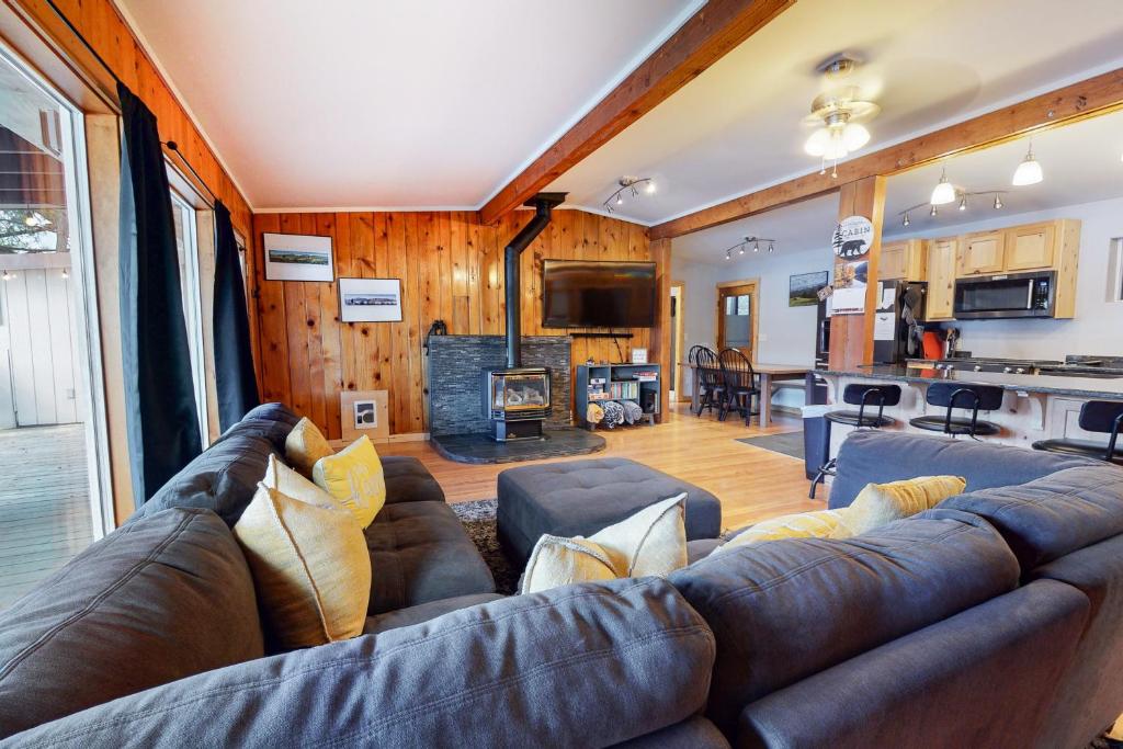 a living room with a large couch and a kitchen at Bear Creek Cottage in Joseph