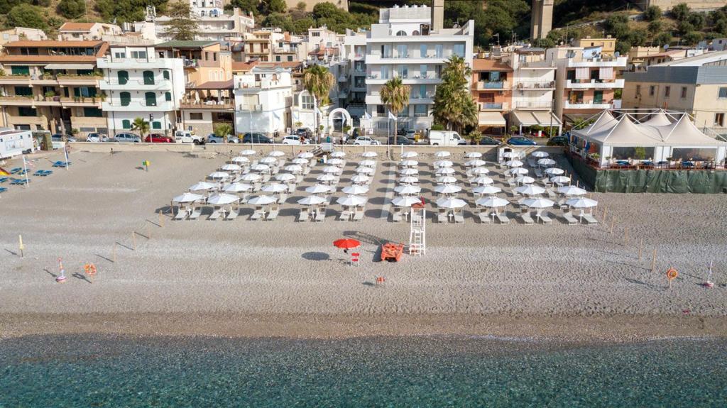 a beach with chairs and umbrellas on the beach at Albatros Beach Hotel in Letojanni