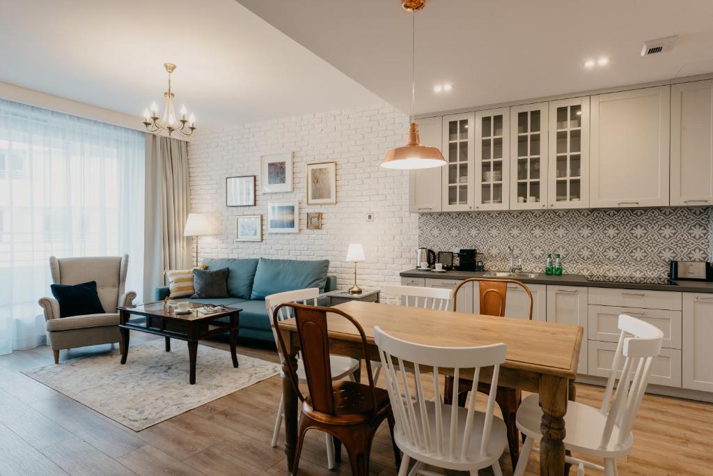 cocina y sala de estar con mesa y sofá en EXCLUSIVE Aparthotel en Wroclaw