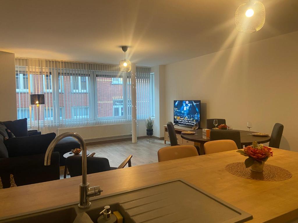 a living room with a table and a tv at Modern appartement centrum Oostende in Ostend