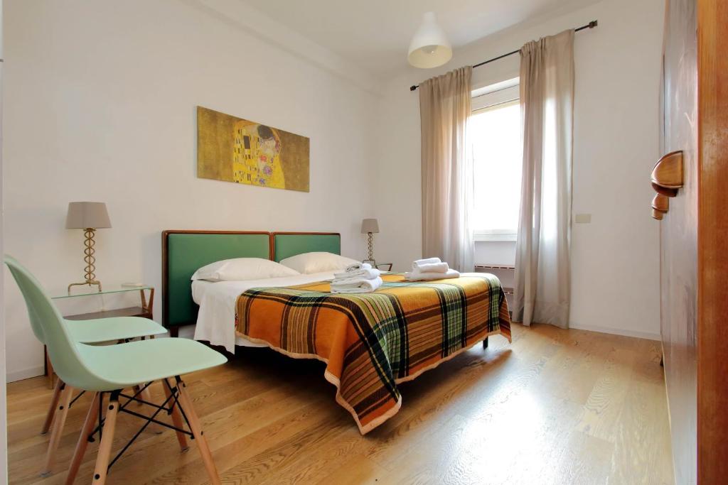 ローマにあるTrastevereのベッドルーム1室(ベッド1台、椅子、窓付)